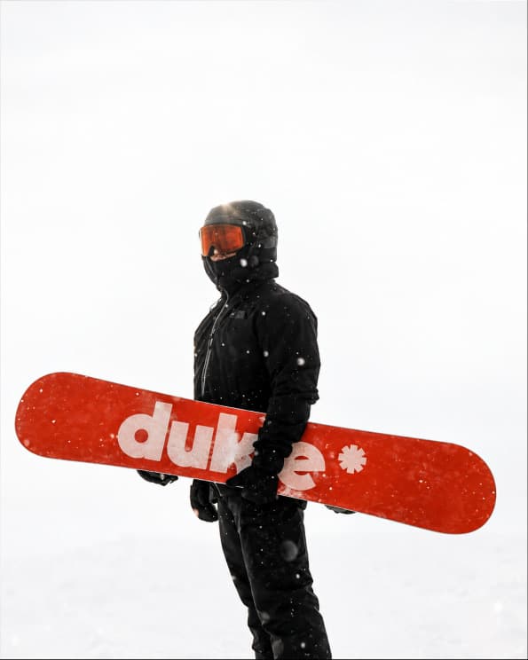 Snowboarder con una tabla roja de Duke